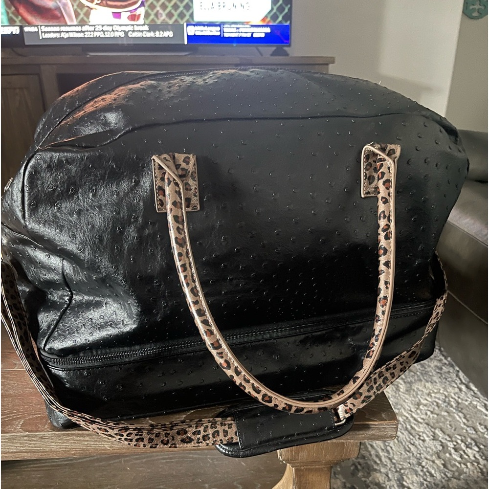 Black carry on travel bag, black pebbled with cheetah pattern.